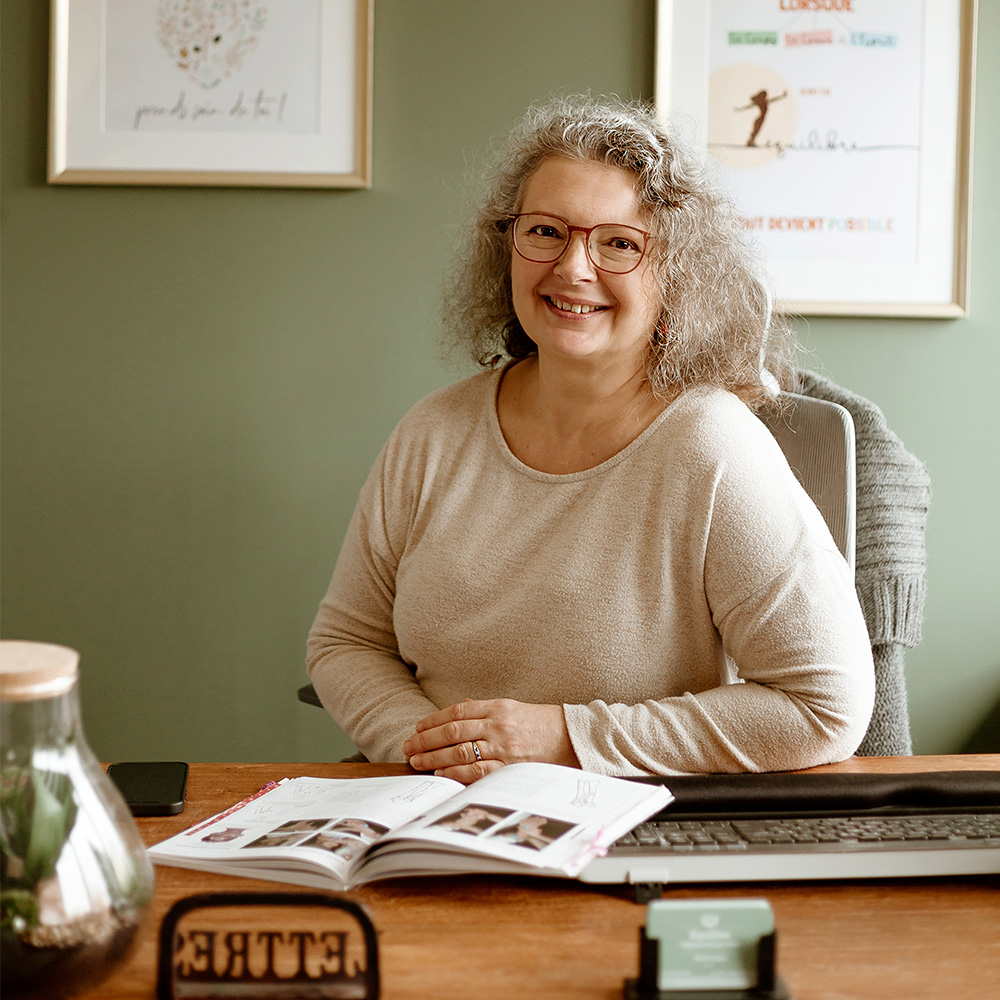 Portrait de Stéphanie Soreau-Dinis, kinésiologue, derrière son bureau au sien de cabinet à Jugon-les-Lacs